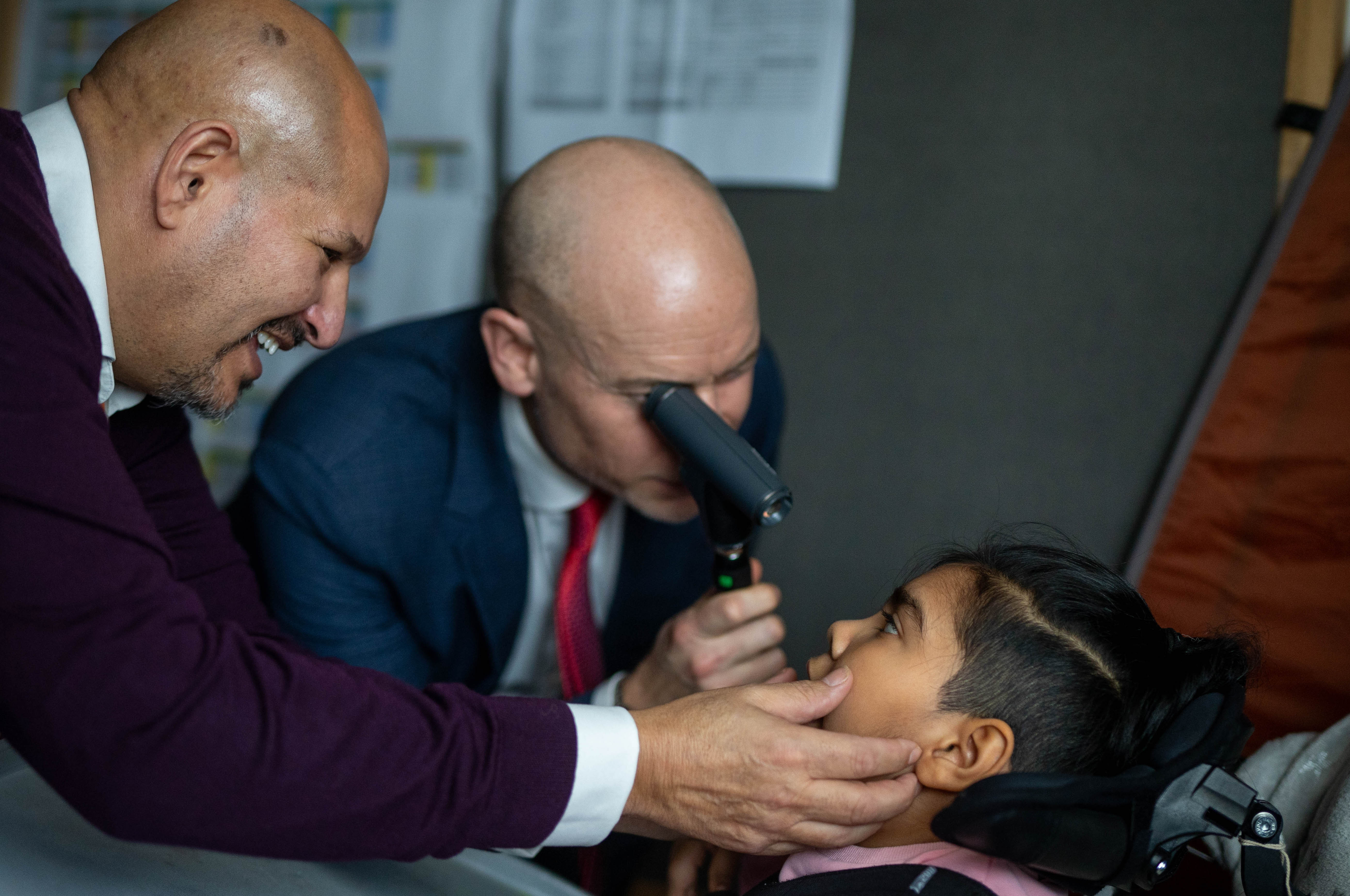 MP Stephen Kinnock testing a girl's eyes