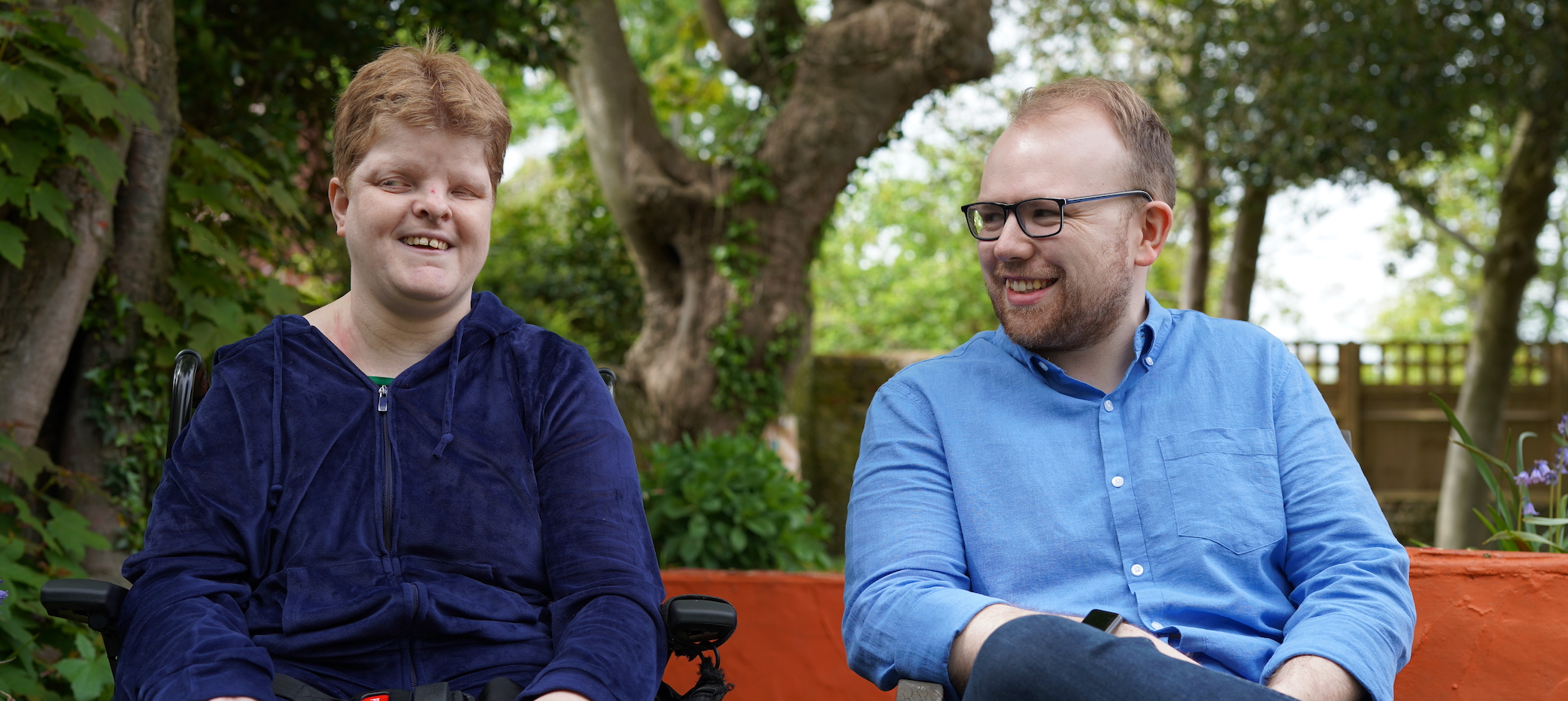 Emily sitting in the garden with her employment support coach, Lewis