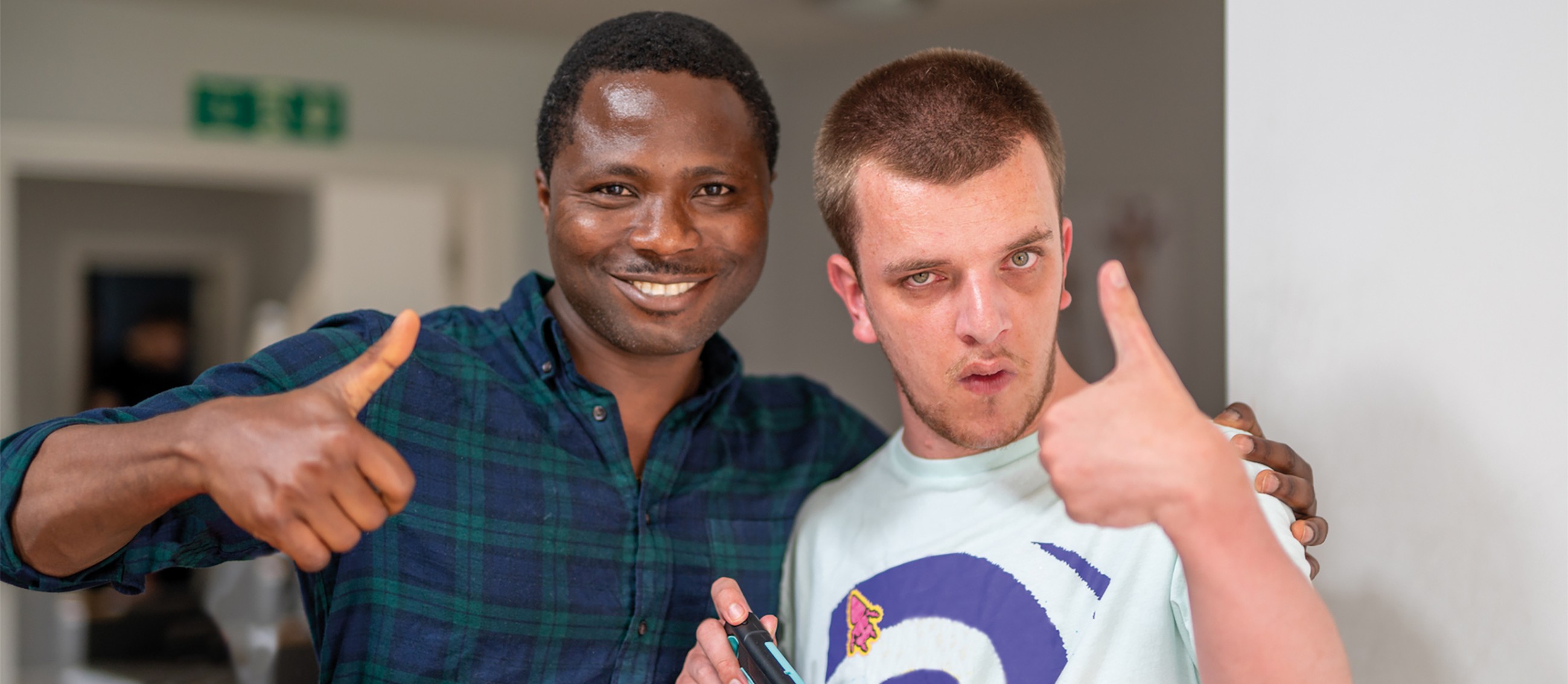Jake giving a thumbs up with a support worker