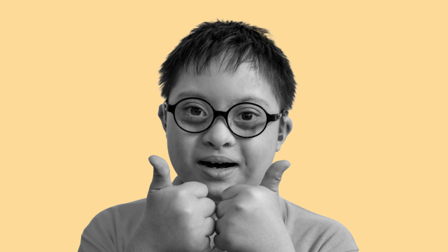 Ethan, a young boy, wearing glasses and doing a thumbs up